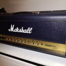 Kytarový zesilovač značky Marshall v modrém texturovaném potahu s černými rohy. Na zlatém předním panelu je nápis VintageModern a text 100W VALVE AMP…