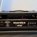 Zadní strana černého kytarového komba s nápisem Hartke a podtiitulem 60 WATT GUITAR AMPLIFIER. Jsou zde viditelné konektory pro napájení, Speaker Out…