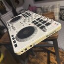 Bílý DJ kontroler značky Numark, který obsahuje dva jog-wheels a několik ovládacích tlačítek a posuvníků. Na horní části je nápis Numark Party Mix Pr…