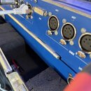 Detail zadní strany modrého elektronického zařízení s řadou konektorů. Jsou vidět nápisy LINK/ACT, DVI a DMX u příslušných portů. Do některých vstupů…