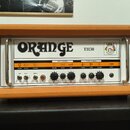 Kytarový zesilovač v oranžovém vinylu s bílým předním panelem. Na panelu je velký nápis ORANGE a označení modelu TH30 spolu s logem. Zesilovač obsahu…