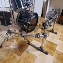 Černá bubnová sada s chromovaným kováním a přidaným chromovaným systémem ramene pro montáž příslušenství. Na basovém bubnu je bílý nápis TAMA. Povrch…