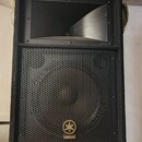 Černý reproduktor v bedně potažené látkovým povrchem. Horní část tvoří rohové hrdlo, spodní část je kryta kovovou mřížkou s perforací. V dolní části…