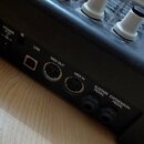 Detail zadní strany černého elektronického hudebního zařízení. Jsou vidět konektory s nápisy POWER 6V DC 1A, USB, MIDI OUT, MIDI IN, SUSTAIN PEDAL a…