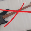 Černá elektrická basová kytara s hnědým hnedobarevným hmatníkem. Na hlavě nástroje je viditelné logo Cort. Tělo má matný povrch a kovové části v stří…