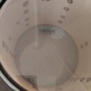 Fotografie zachycuje pohled z horní strany do vnitřku bílého bubnu. Na průhledné bláně je černý nápis REMO AMBASSADOR CLEAR. Uvnitř na spodní bláně j…