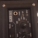 Detail ovládacího panelu černého kytarového komba. Na panelu jsou nápisy STEREO 10 V2, INPUT, LINE IN, MP3/PHONES a EM OUT & PHONES. Jsou zde ovládac…