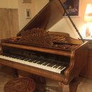 Hnědé dřevěné piano s otevřeným víkem a zdobenou novnotovou deskou. Nad klávesami je zlatý nápis „Kuck Privilegium Adolf Steiner“. Součástí je dřevěn…