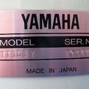 Kovová identifikační pláška s nápisem YAMAHA. Je na ní uveden MODEL TT908 Y a SER. NO. KY11175, v dolní části je nápis MADE IN JAPAN. Povrch plášky m…