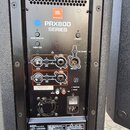 Zadávací panel aktivního reproduktoru s logem JBL PROFESSIONAL a nápisem PRX800 SERIES. Panel obsahuje vstupy pro mikrofon (MIC) a linkový vstup (IN)…