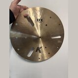 Zlatavý kovový činel s několika otvory různých tvarů a velikostí. Na povrchu jsou čitelné nápisy EFX, 16"/40 cm a logo K. V pravé dolní části je malý…