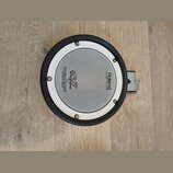 Kruhové elektronické bubnové plochy s bílým pleteným povrchem a černým gumovým okrajem. Na povrchu jsou nápisy Roland, MESH HEAD™ made by REMO a logo…