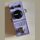 Fialový efekt pedál s nápisy CHORUS MINI a Ibanez. Na horní části jsou tři černé ovládací knoflíky s popisky DEPTH, LEVEL a SPEED, přičemž knoflík SP…