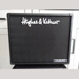 Černý kytarový reproduktor s texturovaným povrchem. V horní části je bílý nápis Hughes & Kettner a v pravém dolním rohu se nachází štítek s nápisem C…
