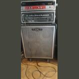 Fotografie zobrazuje basový zesilovač a reprobox v černém provedení. Na horním modulu je nápis GK GALLIEN-KRUEGER a model Fusion 550. Reprobox má stř…