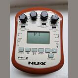 Oranžový efektový pedál s nápisy PA-2, ACOUSTIC G-EFX a NUX. Zařízení má čtyři černé otočné ovladače s popisky BODY/comp, VOLUME/bass, MOD/mid a AMB/…
