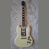 Krémově bílá elektrická kytara typu SG značky Epiphone. Na hlavě je nápis Epiphone a na krytce snímačů text Les Paul Special. Nástroj má dva humbucke…