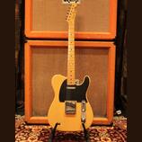 Světle žlutá elektrická kytara typu Telecaster s černým pickguardem a javorovým hmatníkem. Na hlavě krku je nápis Fender Telecaster. Tělo i hmatník v…