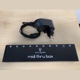 Černý obdélníkový modul s nápisy erica synths a midi thru box. Na horní hraně se nachází osm očíslovaných vstupů, konektor s označením 9V DC a vstup…