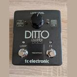 Černý kytarový pedál s nápisy DITTO LOOPER a tc electronic. Horní část obsahuje ovratový knoflík s popiskem LOOP LEVEL a dvě textová pole s funkcemi…