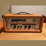 Kytarový zesilovač v oranžovém vinylovém potahu s černými ochrannými rohy a úchytkou. Na předním panelu je velký nápis ORANGE a logo s heraldickým zn…