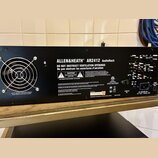 Zadní strana černého rackového zařízení s nápisem ALLEN&HEATH AR2412 AudioRack. Na šasi jsou umístěny varovné štítky s texty CAUTION, RISK OF ELECTRI…