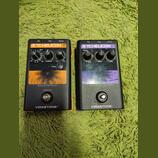 Dvě efektové pedály řady VOICETONE™ značky T.CHELICON v černém provedení. Levý pedál s oranžovým detailem nese nápisy E1 ECHO & TAP DELAY a ovládací…