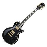 Černá elektrická kytara typu Les Paul s bílým lemováním korpusu a hmatníku. Na hlavě je nápis Epiphone a logo v podobě písmena E. Nástroj má zlaté po…