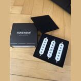 Černá krabice s nápisem TONERIDER GUITAR & BASS PICKUPS obsahuje tři bílé snímače s kovovými polosněma. Na spodní části krabice jsou texty SCATTERWOU…