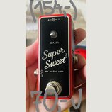 Červený kytarový efekt s černým čelním panelem. Na panelu je nápis GAIN, velký bílý nápis Super Sweet N a text BY xotic usa. V horní části je označen…