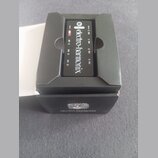 Černý napájecí adaptér značky electro-harmonix umístěný v originální černé krabici. Na zařízení je bílý nápis electro-harmonix a označení 9V u jednot…