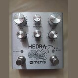 Stříbrný efekt pedál s kovovým povrchem a nápisy HEDRA a meris. Zařízení má pět ovládacích knoflíků s popisky KEY, MICRO TUNE, MIX, PITCH 1 a PITCH 2…