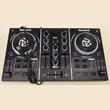Černý DJ kontrolér značky Numark s modelem PARTY MIX. Zařízení má dva stříbrno-černé jog-wheels, středovou sekci s knoflíky a posuvníky a spodní část…