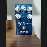 Modrý efekt pedál s nápisy EGO compressor a WAMPLER BUILT IN USA. Zařízení má pět bílých otočných ovladačů s popisky SUSTAIN, TONE, ATTACK, VOLUME a…