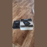 Krabice a černý textilní pouzdro s bílým nápisem BOSE. Na krabici je zobrazen přístroj a texty BOSE, T1 ToneMatch, www.bose.com/ToneMatch a BOSE. Kra…
