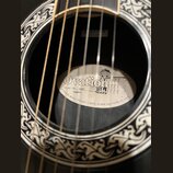 Detail zněkozvuku akustické kytary s ozdobným ornamentem kolem otvoru. Uvnitř je vidět štítek s nápisy Ovation, Model No. 1867 Legend, A KAMAN MUSIC…