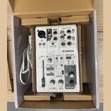 Bílá mixovací konzole Yamaha AG03 MIXING CONSOLE v kartonové krabici s přiloženým bílým USB kabelem. Na horním panelu jsou vstupy pro 2G GUITAR, MONO…