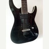 Černá elektrická kytara s výraznou strukturou dřeva na povrchu korpusu. Nástroj má dva humbuckery, jeden ovládací knoflík hlasitosti a jeden tónu. Na…