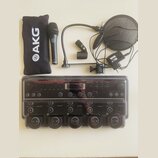 Sada vybavení obsahující černý mikrofon s logem AKG, ohybné rameno, pop-filtr a černý přepravní vak s nápisem AKG. V dolní části je elektronické zaří…