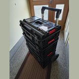 Černý plastový systém kufříků na kolečkách s teleskopickou rukojetí. Na boku horního a prostředního kufříku je viditelný nápis HOBERICK. Kufry mají č…