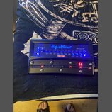 Černý kytarový procesor s modrým podsvícením tlačítek a nápisů. Na horní části je modré logo Hughes & Kettner a modelový název Black Spirit 200. Zaří…