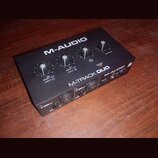 Černý zvukový interface M-AUDIO M-TRACK DUO v kovovém provedení. Na horní straně jsou tři otočné ovladače a nápisy SIGNAL / CLIP INPUT 1, SIGNAL / CL…