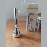 Stříbrný kovový moutník s doprovodnou krabičkou. Na spodní části moutníku je vyryto slovo EXCLUSIVE. Na krabičce jsou nápisy EXCLUSIVE, 9890108 a ští…