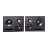 Dva černé studiové monitory s výrazným hranatým tvarem. Na každém je umístěn velký nízkofrekvenční měnič, menší středový reproduktor a v horní části…