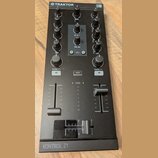 Černý DJ kontrolér s nápisy TRAKTOR a KONTROL Z1. Zařízení obsahuje několik otočných knoflíků, posuvníky hlasitosti pro kanály A a B, crossfader a tl…