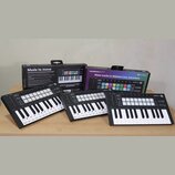 Tři černé MIDI kontroléry s klávesami a barevnými pady, umístěné před dvěma původními krabicemi. Na zařízeních i na obalech je vidět nápis LAUNCHKEY…