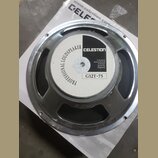 Fotografie znázorňuje zadní stranu reproduktoru s kovovým rámem stříbrné barvy. Na magnetu je bílo-černý štítek s nápisy PROFESSIONAL LOUDSPEAKER, CE…