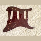 Tmavě červený pickguard s texturou želvy (tortoise shell) určený pro elektrickou kytaru. Má tři vyřezané otvory pro snímače a několik otvorů pro šrou…
