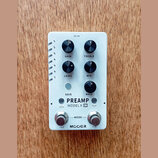 Bílý efekt pedál s nápisy PREAMP a MODEL X X2. Zařízení má pět černých otočných ovladačů s popisky GAIN, TREBLE, LEVEL, MID a BASS, jedno tlačítko SA…