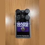 Kytarový efekt v stříbrném kovovém šasi s fialovým předním panelem. Na panelu jsou čtyři černé ovládací knoflíky s popisky DEPTH, RATE, BASS a TREBLE…